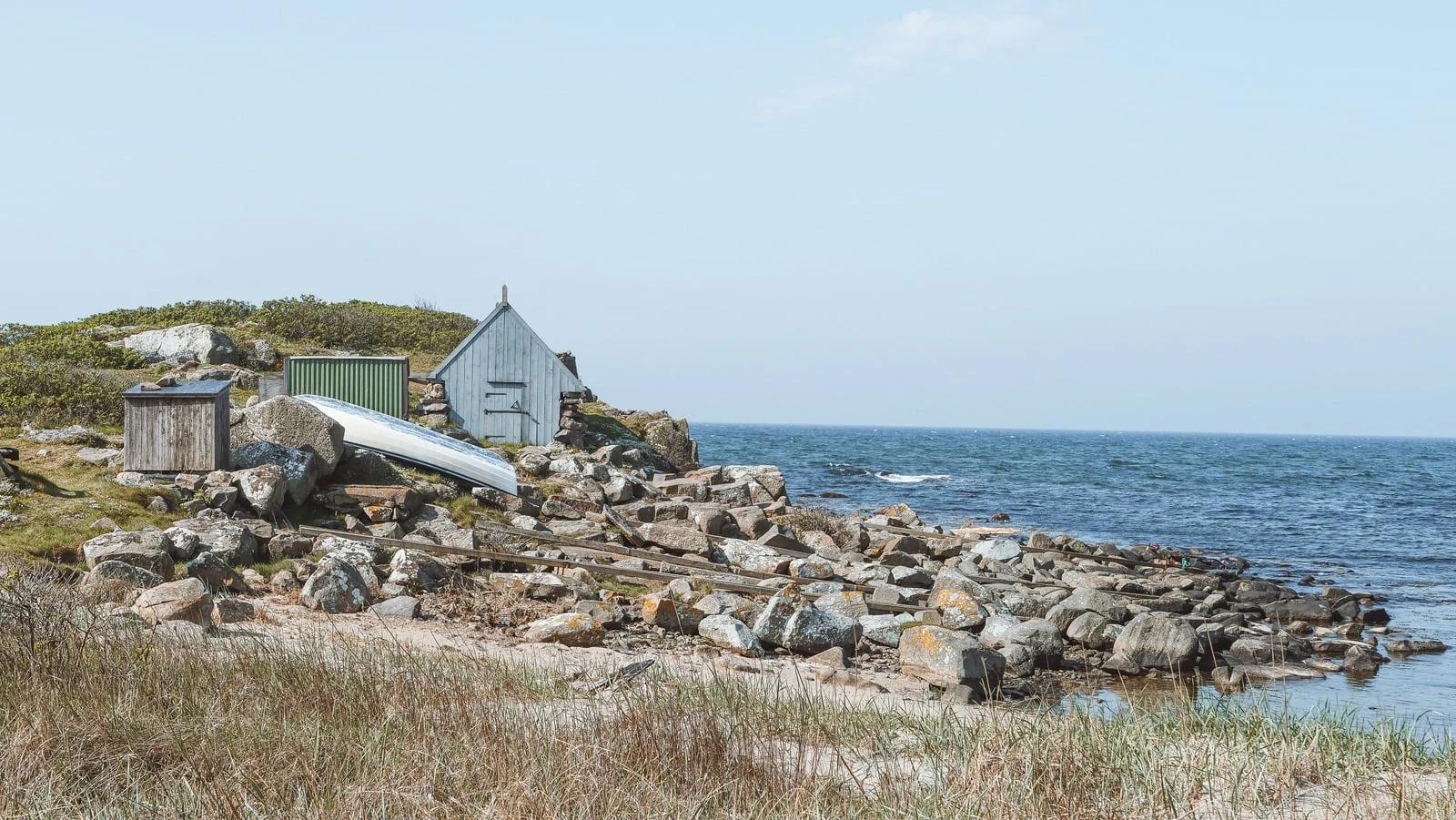 Kustlandskap med klippor och ett vitt hus vid havet