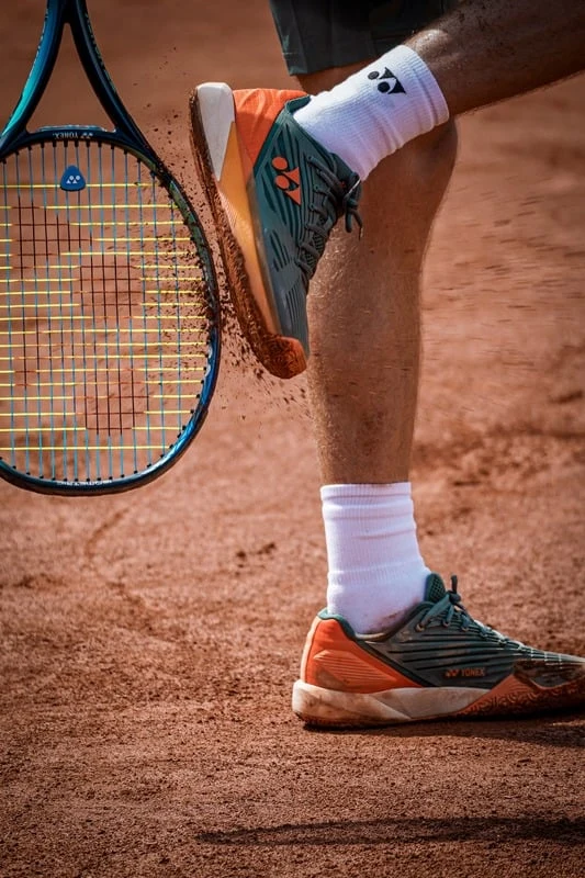 Tennisspelare med racket på en grusbana